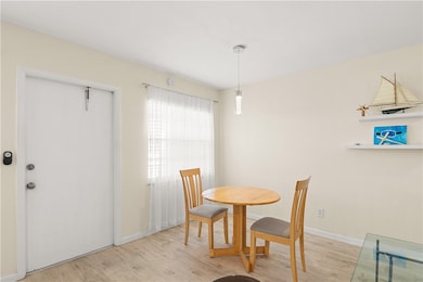 Dining area featuring light wood-style floors and baseboards