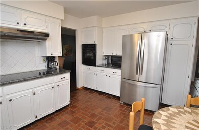 Kitchen has granite countertops & ceramic tile bac