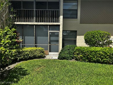 Property entrance with stucco siding and a lawn