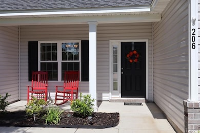 Entrance to property featuring roof with shingles and a porch