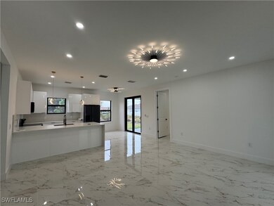 Kitchen with white cabinetry, sink, black refriger