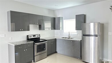Kitchen featuring appliances with stainless steel finishes, gray cabinetry, and light tile patterned flooring
