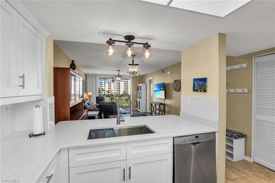 Kitchen featuring stainless steel dishwasher, backsplash, light countertops, a sink, and white cabinetry