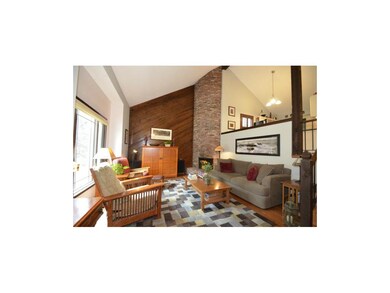 Living room with soaring, cathedral ceilings leadi
