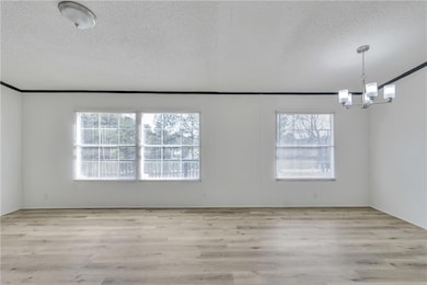 Unfurnished room with a textured ceiling, an invit