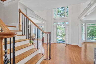 Foyer featuring light wood-style floors, a chandelier, and crown molding