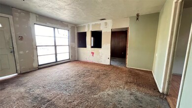 Unfurnished room with a textured ceiling and carpe
