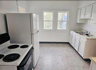 Kitchen with white range oven, light tile flooring
