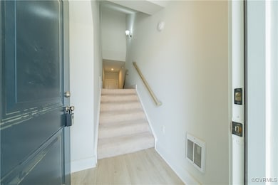Stairway with wood finished floors and baseboards