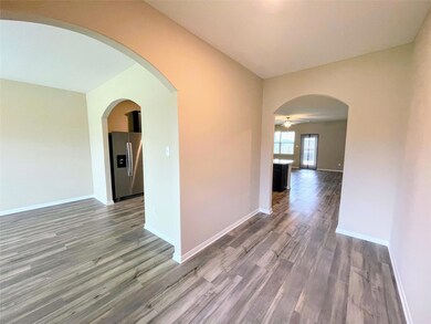 Spare room with arched walkways, baseboards, wood 