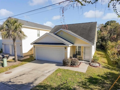 View of front of house with concrete driveway, a garage, a shingled roof, and a front yard