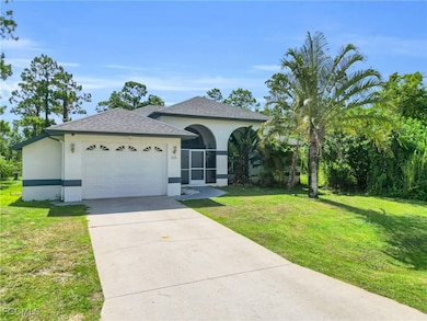 Single story home with roof with shingles, a front yard, a garage, driveway, and stucco siding