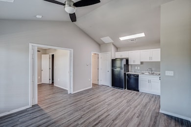 Kitchen with white cabinetry, lofted ceiling, black appliances, light wood-style flooring, and ceiling​​‌​​​​‌​​‌‌​​‌​​​‌‌​​​​​​‌‌‌​​‌​​‌‌​​​‌ fan