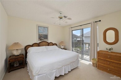 Bedroom featuring a textured ceiling, a ceiling fan, light colored carpet, and access to exterior