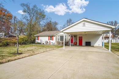 Two car carport with additional parking in the extensive concrete driveway.