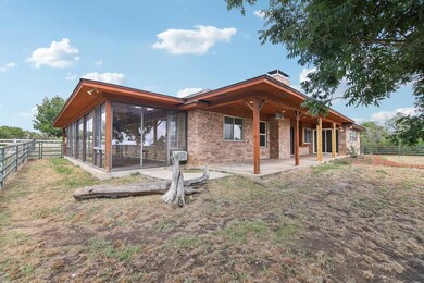 Back of property with a patio and a sunroom
