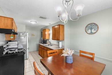 Kitchen featuring decorative light fixtures, an inviting chandelier, light tile floors, sink, and electric range oven