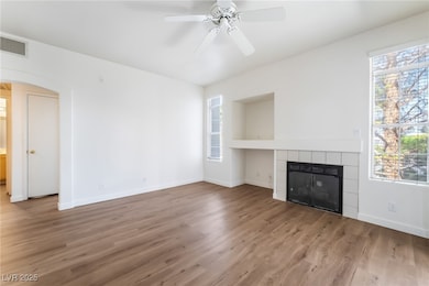 Unfurnished living room with arched walkways, a ti