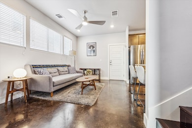 Living room with baseboards, visible vents, concr