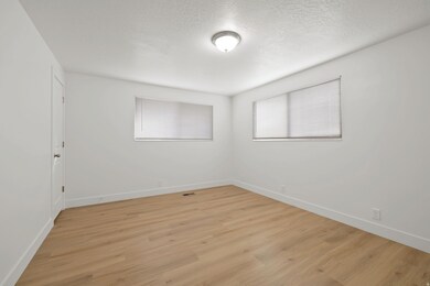 Spare room featuring light wood finished floors and a textured ceiling