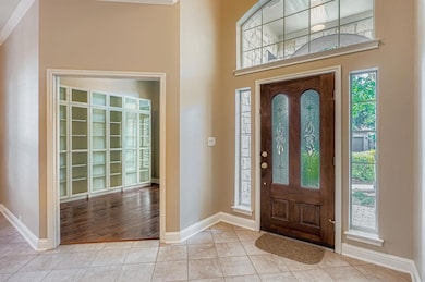Foyer with tile patterned floors and crown molding