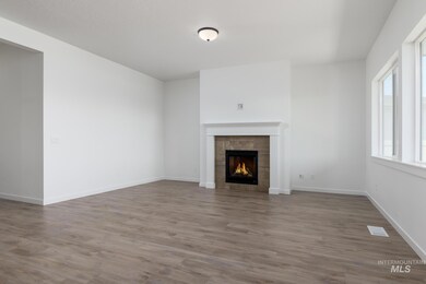 Unfurnished living room with a tiled fireplace and wood finished floors