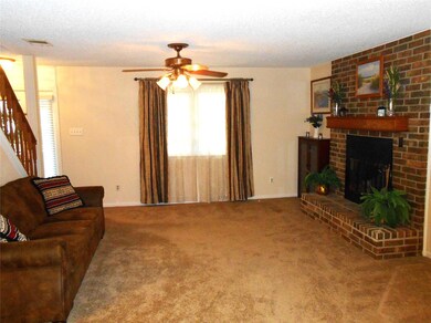 Living room with a brick fireplace, carpet, ceilin