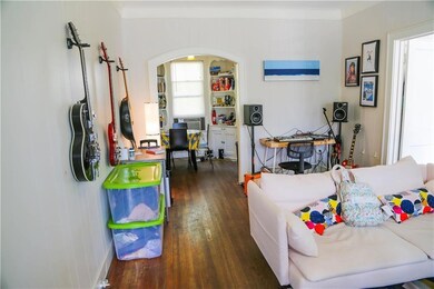 Living area with wood finished floors, crown mold