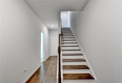 Stairs with baseboards, wood finished floors, and recessed lighting