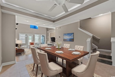 Dining area with light tile patterned floors, a ceiling fan, stairs, ornamental molding, and baseboards