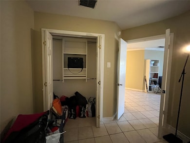 Corridor with light tile patterned floors and ornamental molding