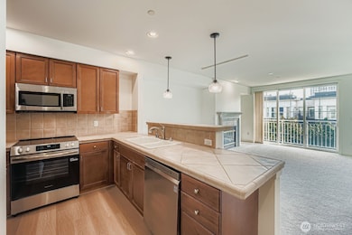 Well-appointed kitchen with stainless steel appliances, wood cabinetry, and bar seating.