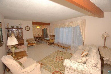 Living room with beamed ceiling, carpet floors, an
