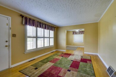 BEAUTIFUL WOOD FINISH FLOORS AND CROWN MOLDING IN THE LIVING ROOM