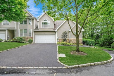 View of front facade with stone siding, asphalt driveway, a garage, a front yard, and a shingled roof
