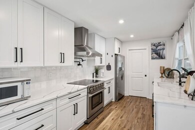 The Stylish Kitchen is a showstopper featuring Quartz Countertops with Striking Veining, White Shaker Cabinets, Stainless Steel Appliances, and a Premium Thor Gas Range.