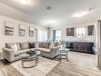 Living area with light wood-style floors and lofted ceiling