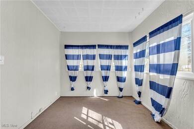 Carpeted spare room featuring a textured wall