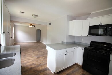 Kitchen featuring white cabinets, black appliances