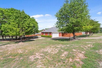 View of yard featuring fence and a garage
