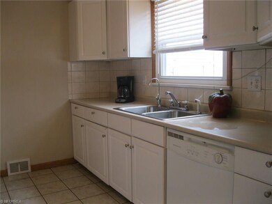 Ceramic tile floor, white kitchen appliances can s