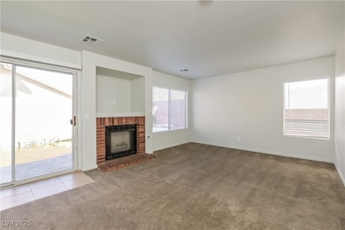 Unfurnished living room featuring light carpet and a brick fireplace