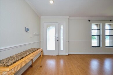 Foyer entrance featuring crown molding, wood finished floors, and baseboards