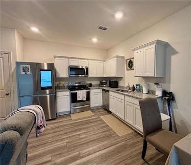Kitchen with sink, light hardwood / wood-style flo