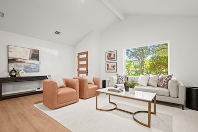 Living area featuring beam ceiling, light wood-type flooring, and high vaulted ceiling