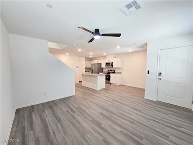 Unfurnished living room with a ceiling fan, light