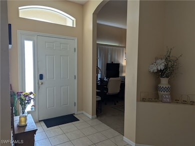 Entrance foyer featuring arched walkways, light ti