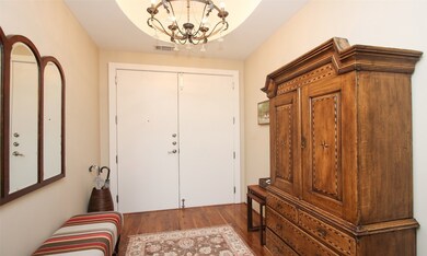 View of the entry from inside. Notice the impressive double doors and stunning iron & crystal chandelier.