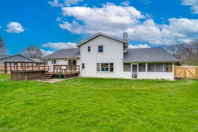 Back of property with a wooden deck and a yard