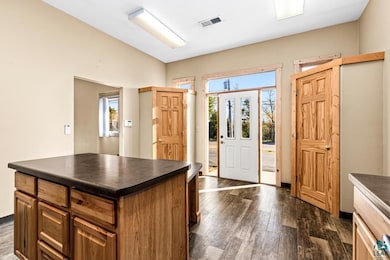 Entrance foyer with dark wood-style floors, a weal